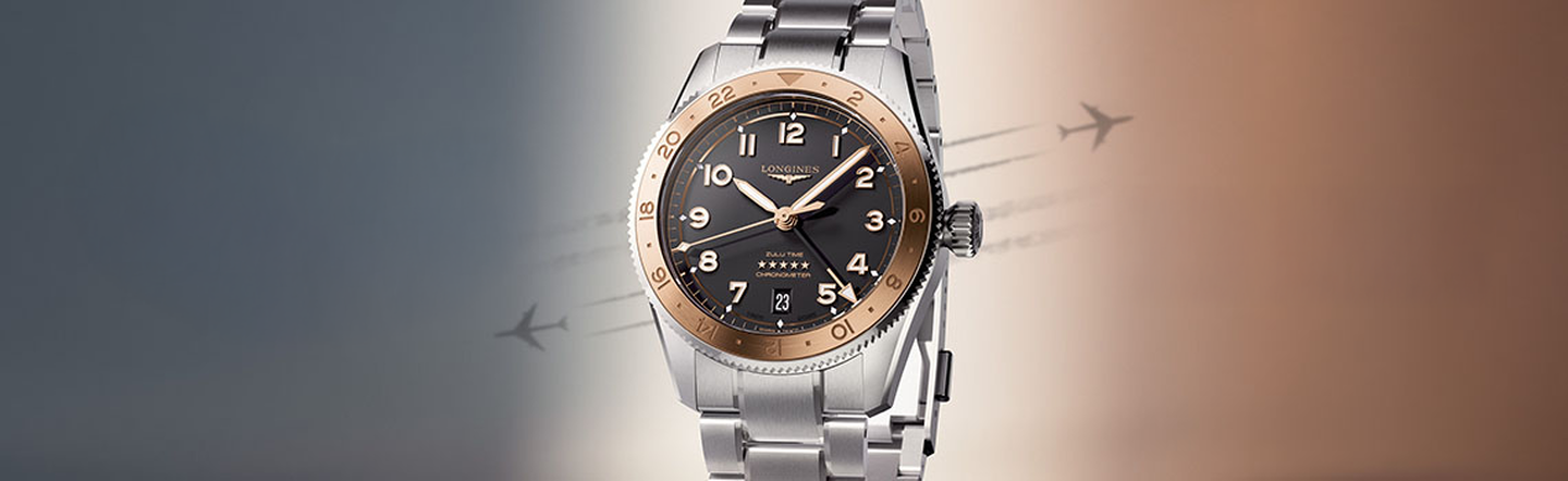 Longines Zulu a luxury wristwatch with steel band and dark dial featuring rose gold bezel, set against a gradient background with airplane silhouettes symbolizing elegance and travel.